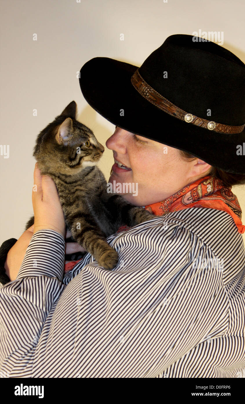 Une cowgirl tenant un chaton Banque D'Images