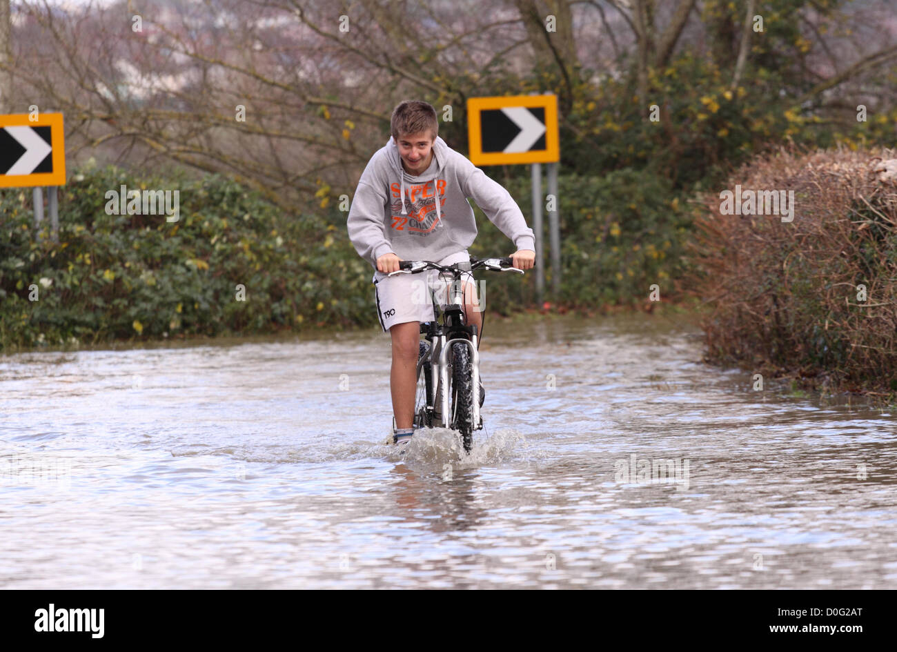 Street, Somerset, England, UK - 25 novembre 2012. Les routes secondaires entre Glastonbury et Street près de la rivière Brue a été inondée - jeunes ont l'occasion d'avoir du plaisir dans les inondations. Banque D'Images