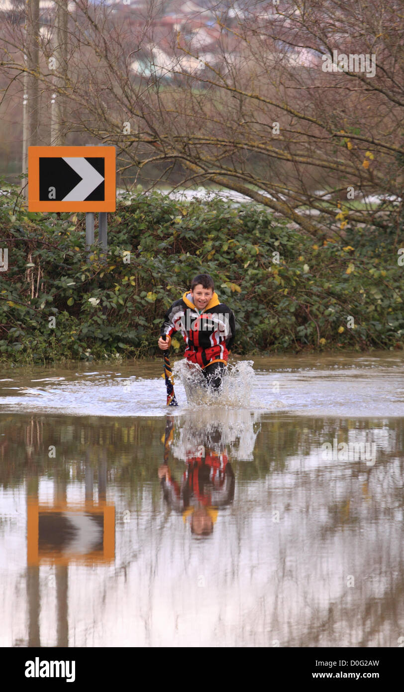 Street, Somerset, England, UK. Novembre 2012. Les routes secondaires entre Glastonbury et Street près de la rivière Brue a été inondée - jeunes ont l'occasion d'avoir du plaisir dans les inondations - Banque D'Images