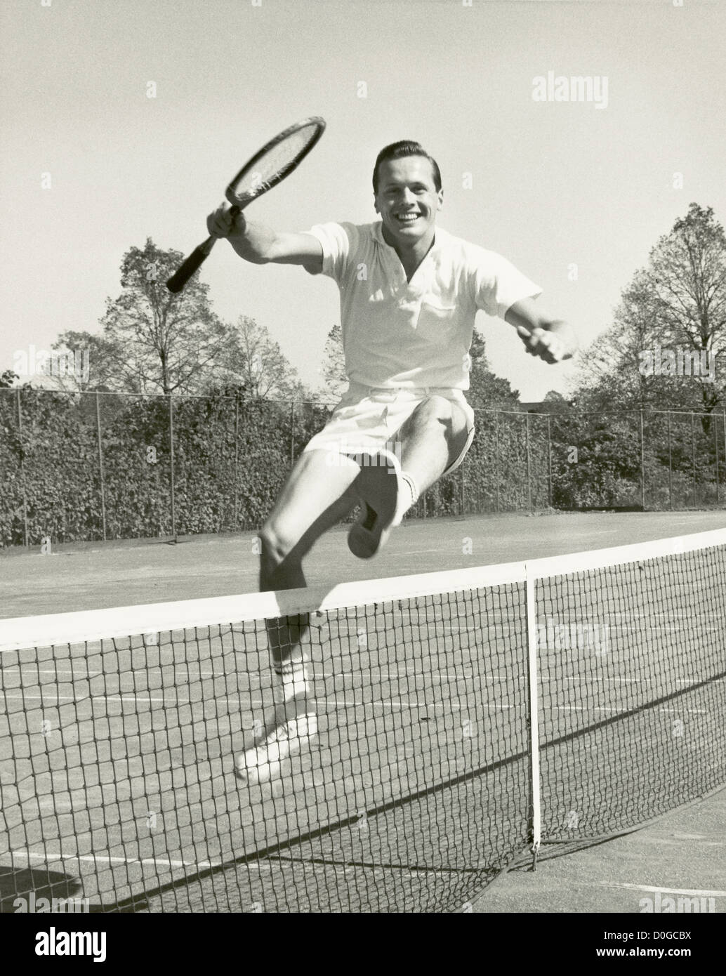 Sautant par-dessus l'homme net raquette de tennis avec Banque D'Images