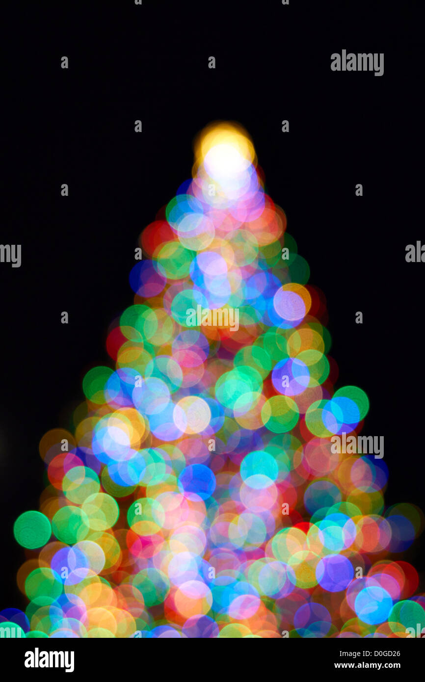 Arbre de Noël avec des couleurs de lumière floue sur fond noir Banque D'Images