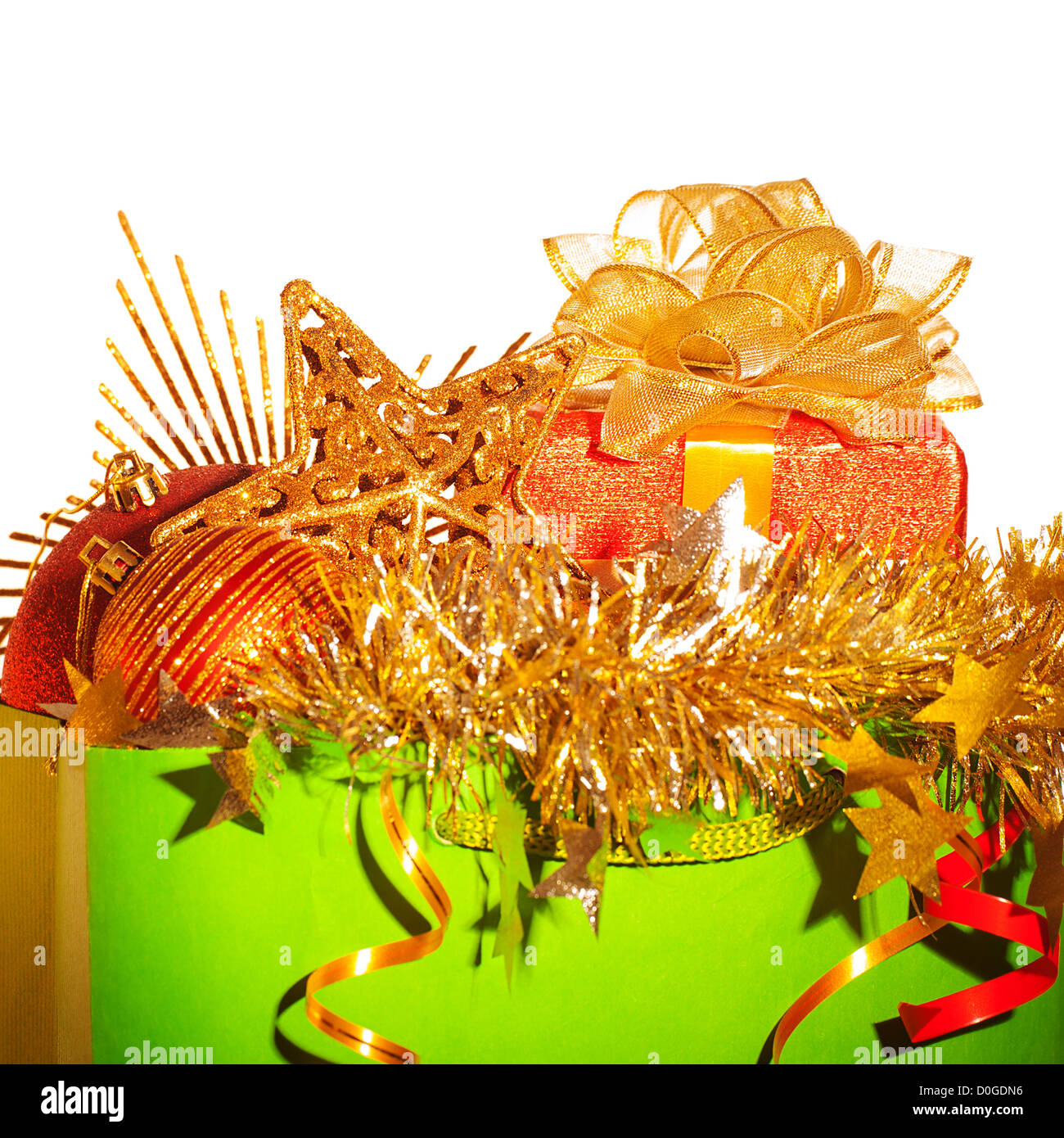 Photo de vert sac de papier avec des trucs de Noël isolé sur fond blanc, différentes décorations de Noël en sac de shopping, Banque D'Images