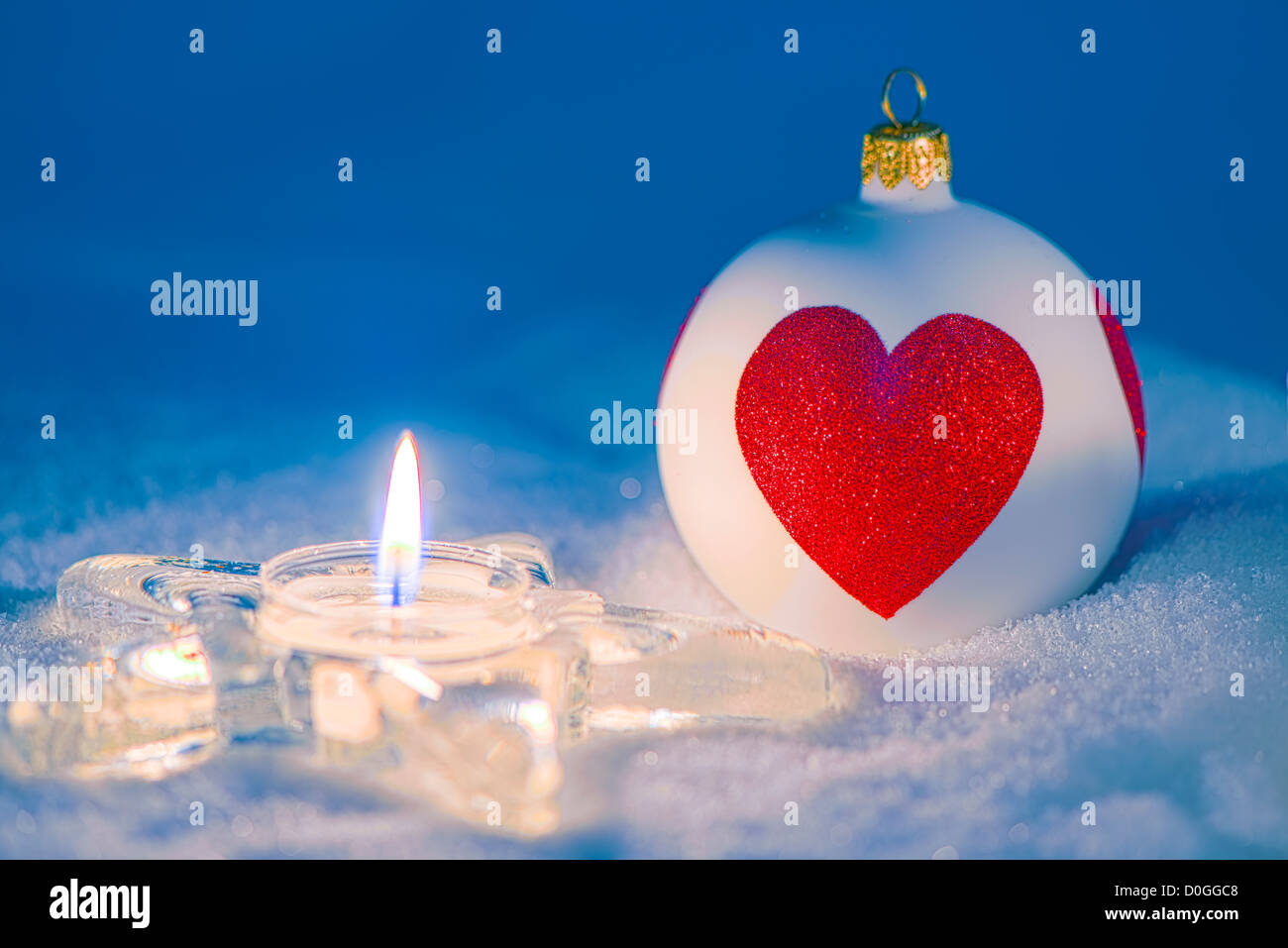 Noël enneigé. Décorations de Noël avec cœur et babiole bougie sur la neige. Banque D'Images