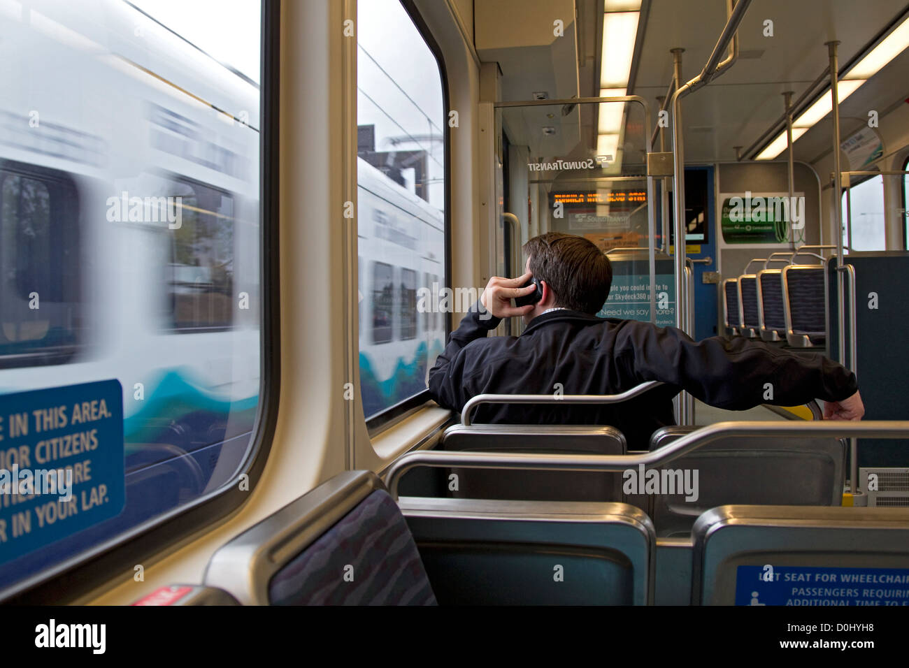 Transport de banlieue et talking on cell phone, sur le train léger, Seattle lien central Banque D'Images
