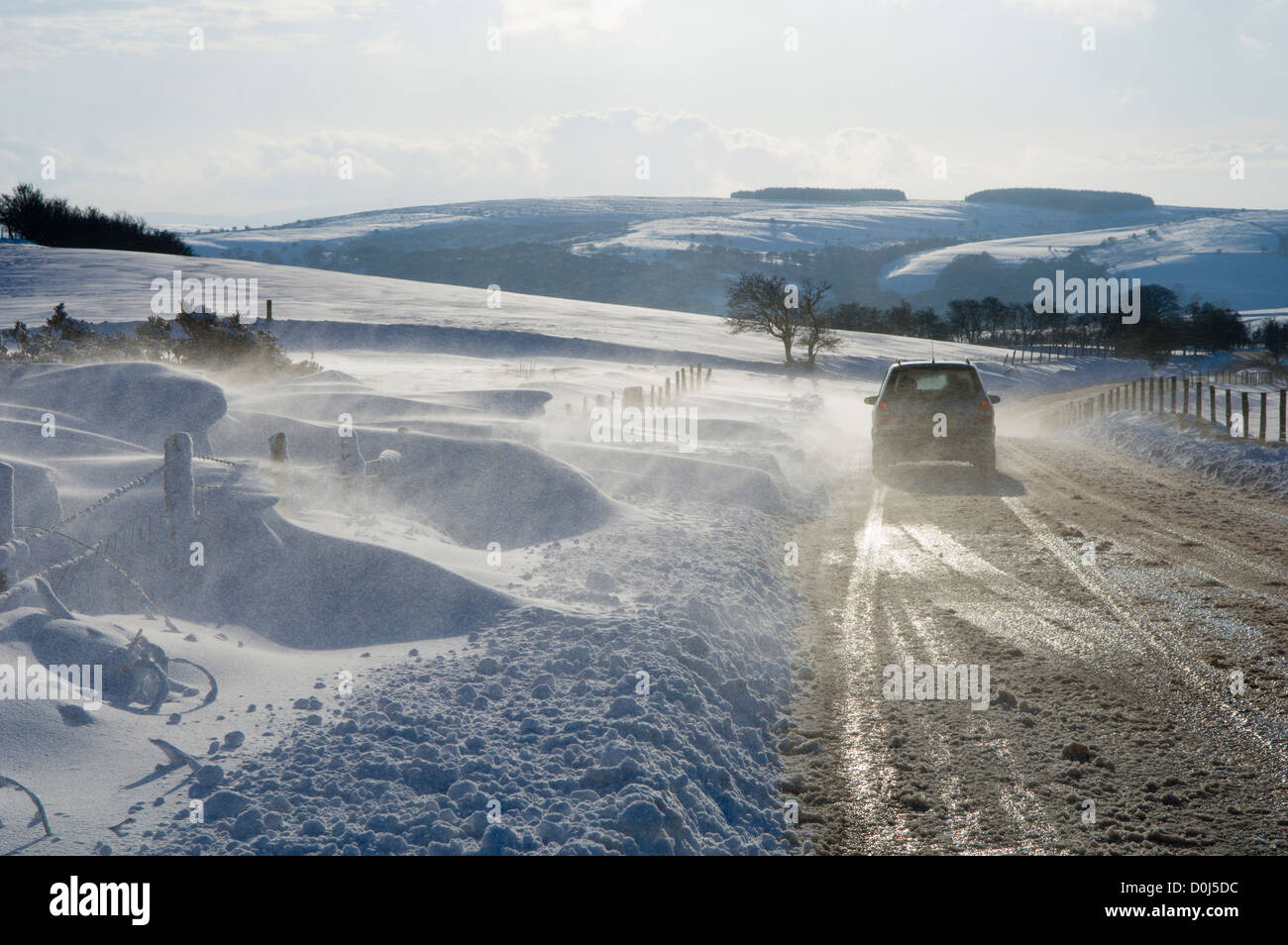 Une voiture roulant dans une tempête de neige à Eppynt dans Powys. Banque D'Images