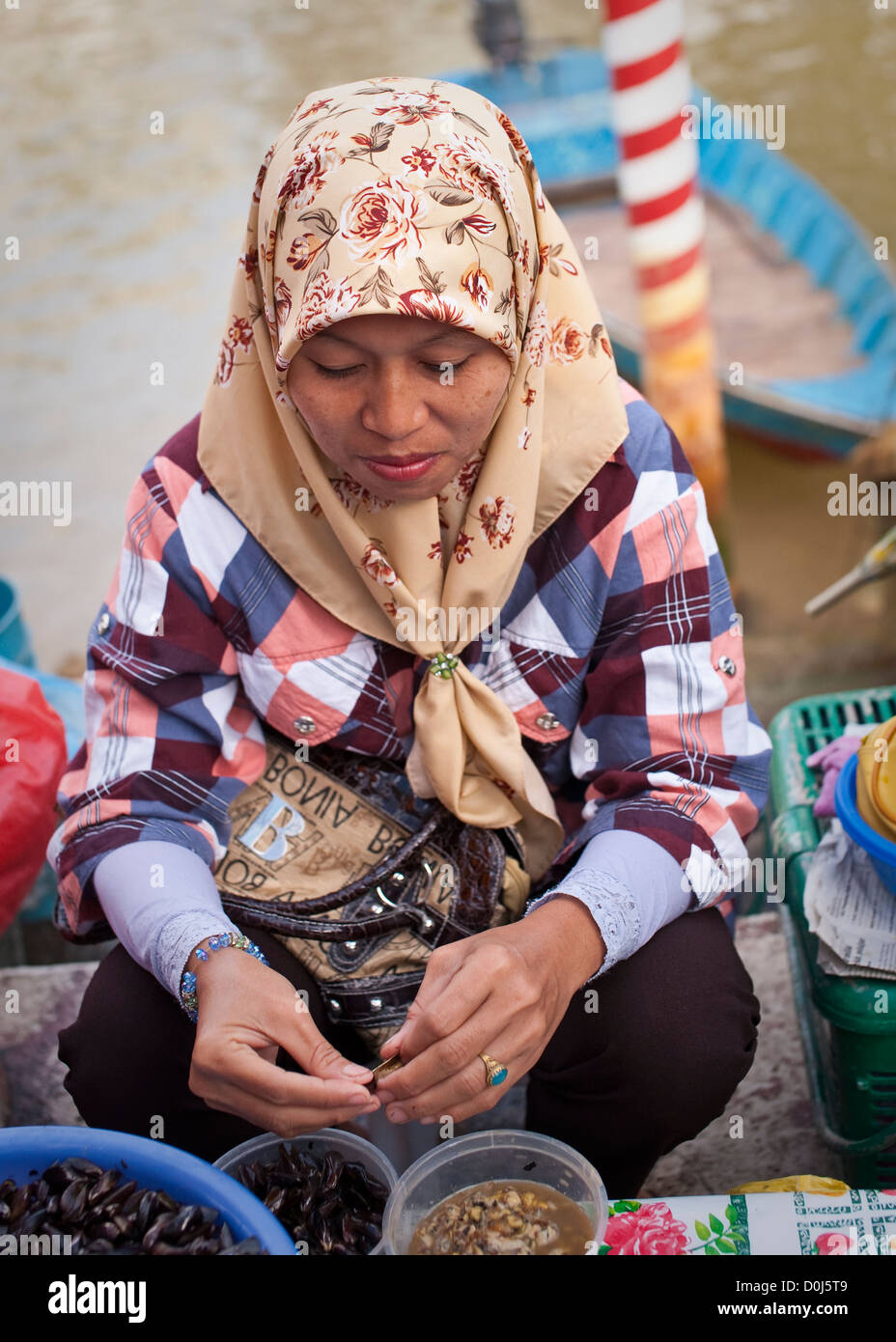 Une femme musulmane la vente des spécialités locales dans le marché aux poissons, Brunei Banque D'Images