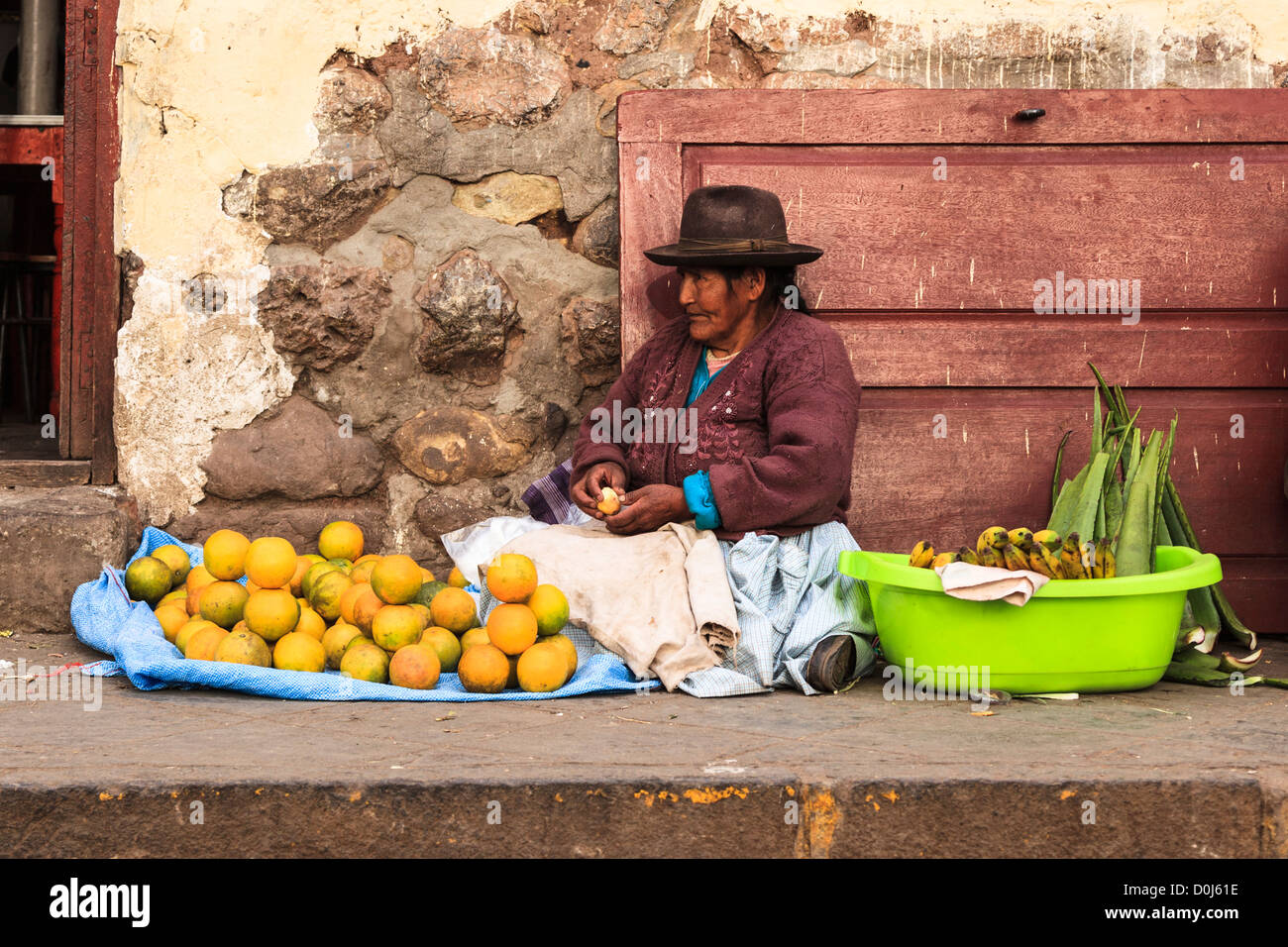 Femme vendant des oranges et des fruits dans la rue market à Cuzco, Pérou Banque D'Images