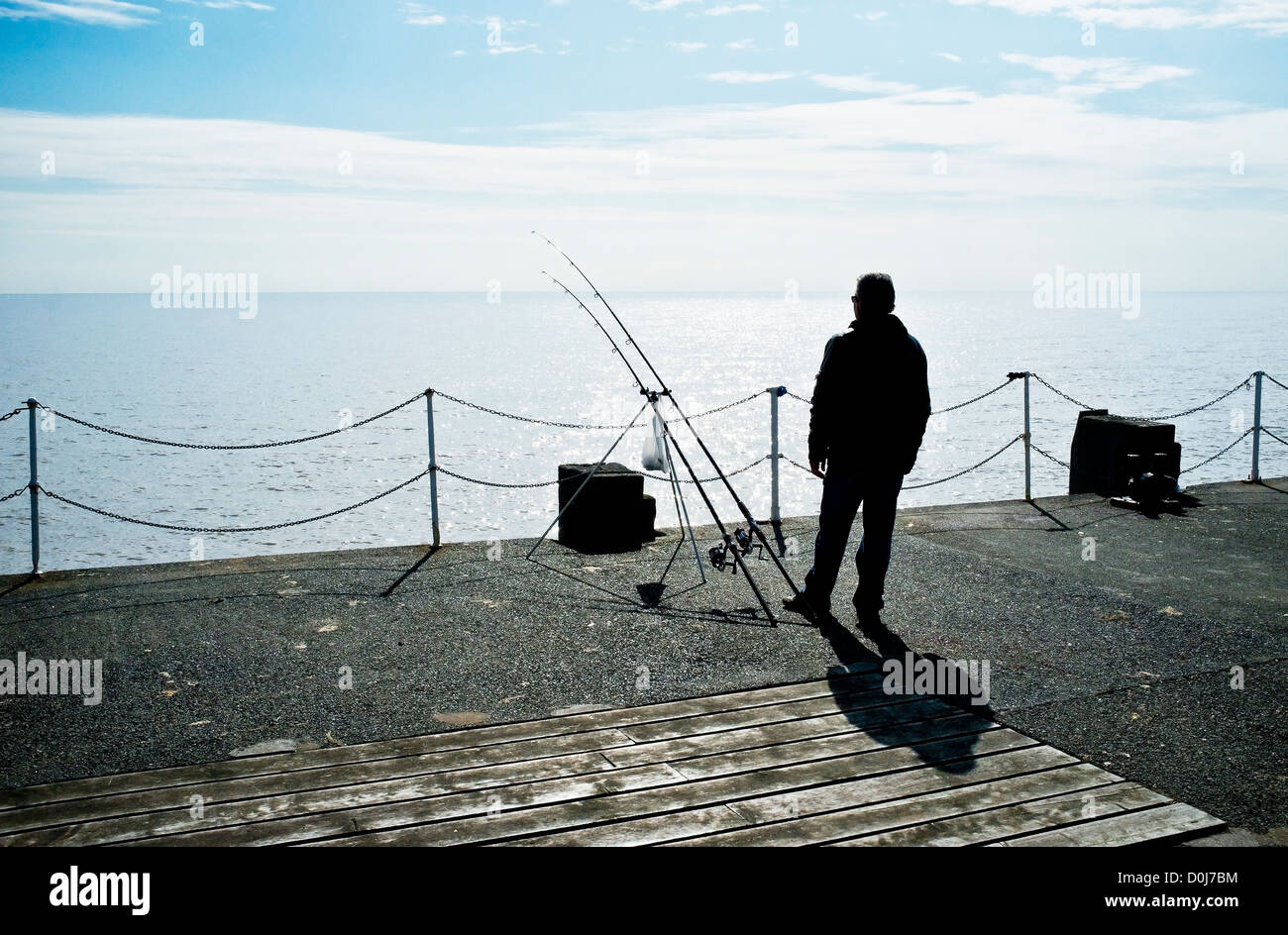 La silhouette d'un pêcheur sur la jetée de Clacton. Banque D'Images