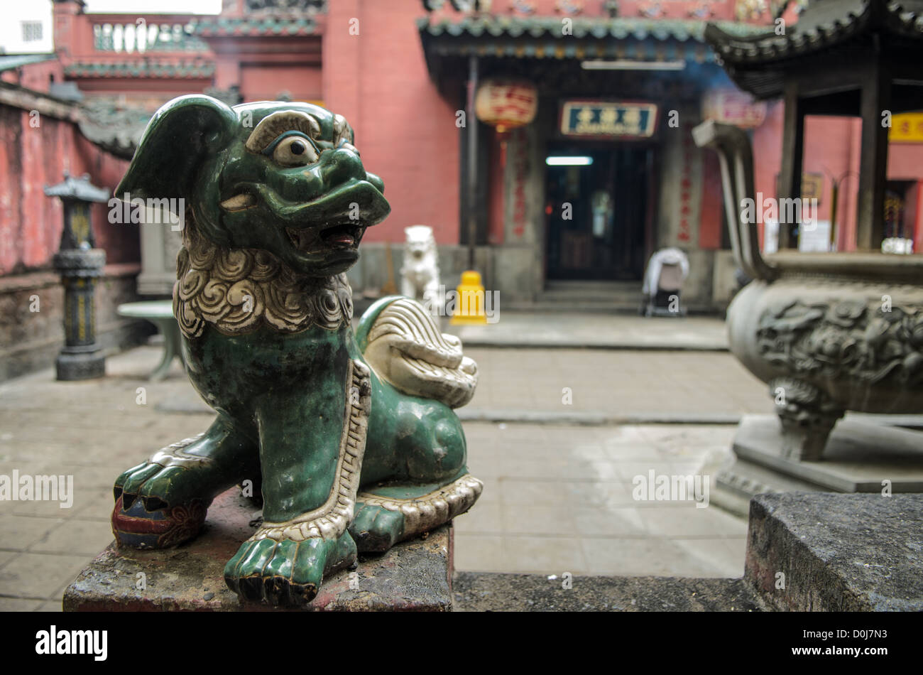 Statue du lion gardien de la pagode de l'empereur de Jade Hô Chi Minh-VILLE // HO CHI MINH-VILLE, Vietnam — Une petite statue de lion gardien vert se dresse à l'entrée de la pagode de l'empereur de Jade dans le quartier Da Kao de Hô Chi Minh-ville. Construit en 1909 et dédié au Dieu suprême taoïste connu sous le nom d'Empereur de Jade, ce temple de style chinois est l'un des sites religieux les plus atmosphériques de la ville. La pagode mélange des éléments des traditions bouddhiste et taoïste, avec des sculptures complexes et statuaires dans tout son complexe. Également connu sous le nom de pagode de la tortue, le temple attire à la fois les fidèles et les visiteurs qui cherchent Banque D'Images