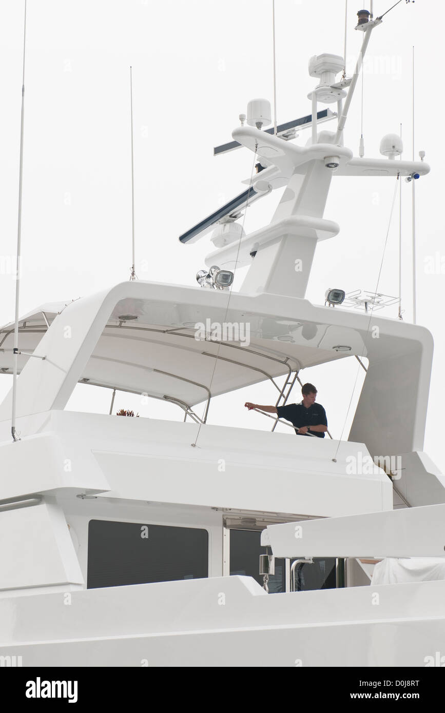 L'homme lave le pont supérieur sur un méga-yacht, NY Banque D'Images