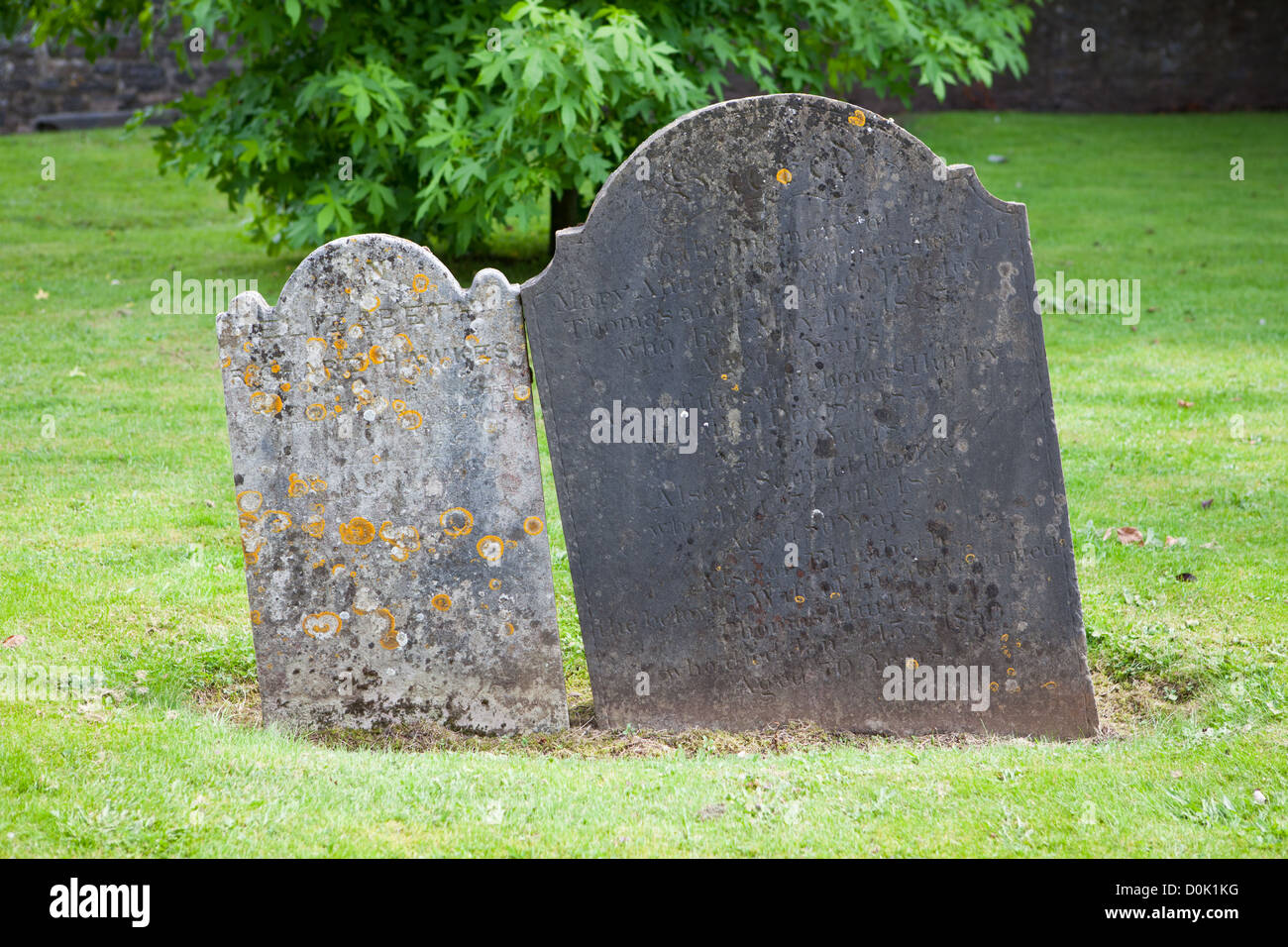 Un couple de pierres tombales leaning ensemble symbolisant l'amour au-delà de la mort dans le cimetière jardin de Saint Peter's Church, Tiverton Banque D'Images