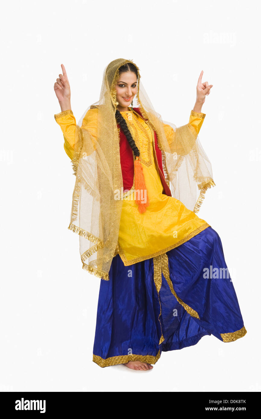 Femme en robe traditionnelle Punjabi jaune faisant bhangra Banque D'Images