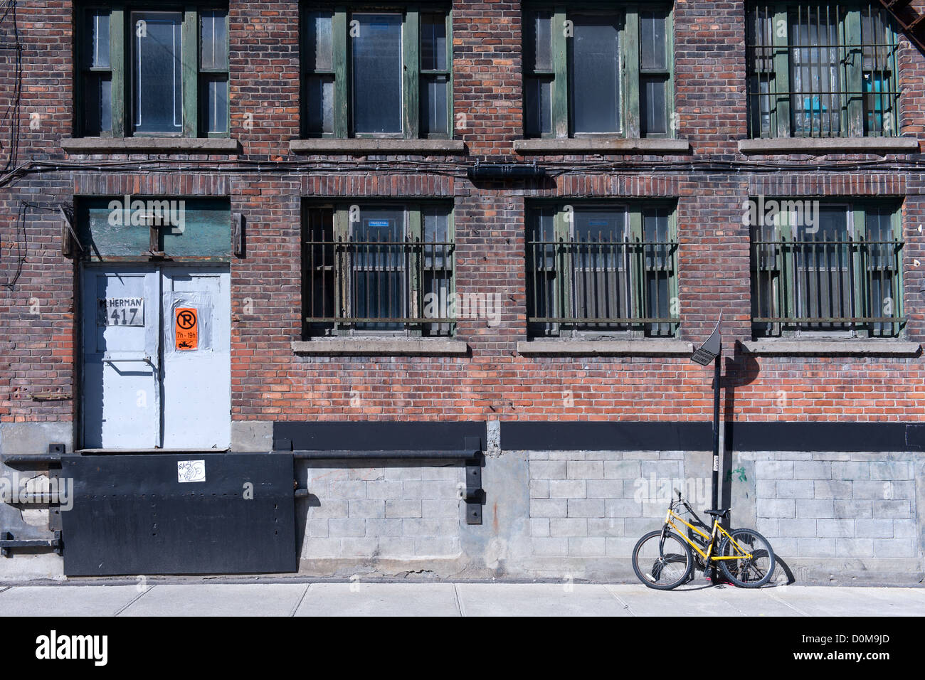 Ancien bâtiment de brique et de vélos appuyé contre le mur dans le centre-ville de Montréal, province de Québec, Canada. Banque D'Images