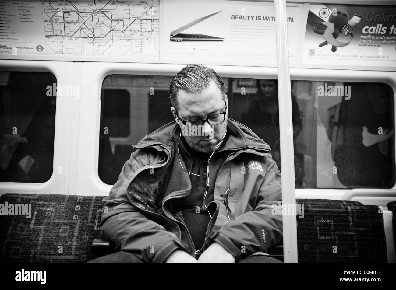 Un homme endormi sur le réseau ferroviaire souterrain à Londres Banque D'Images