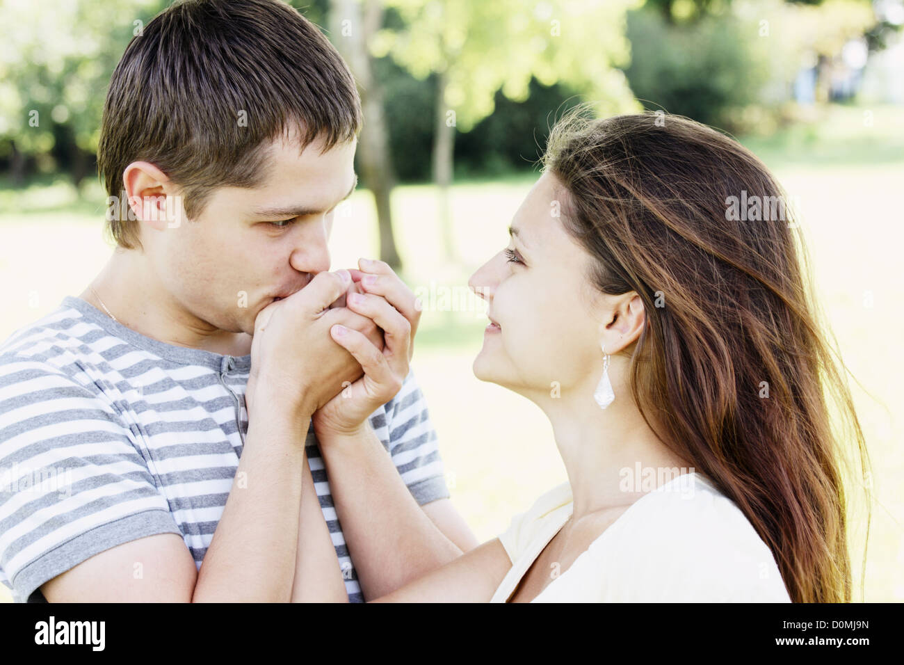 Guy kissing girfriends mains Banque D'Images