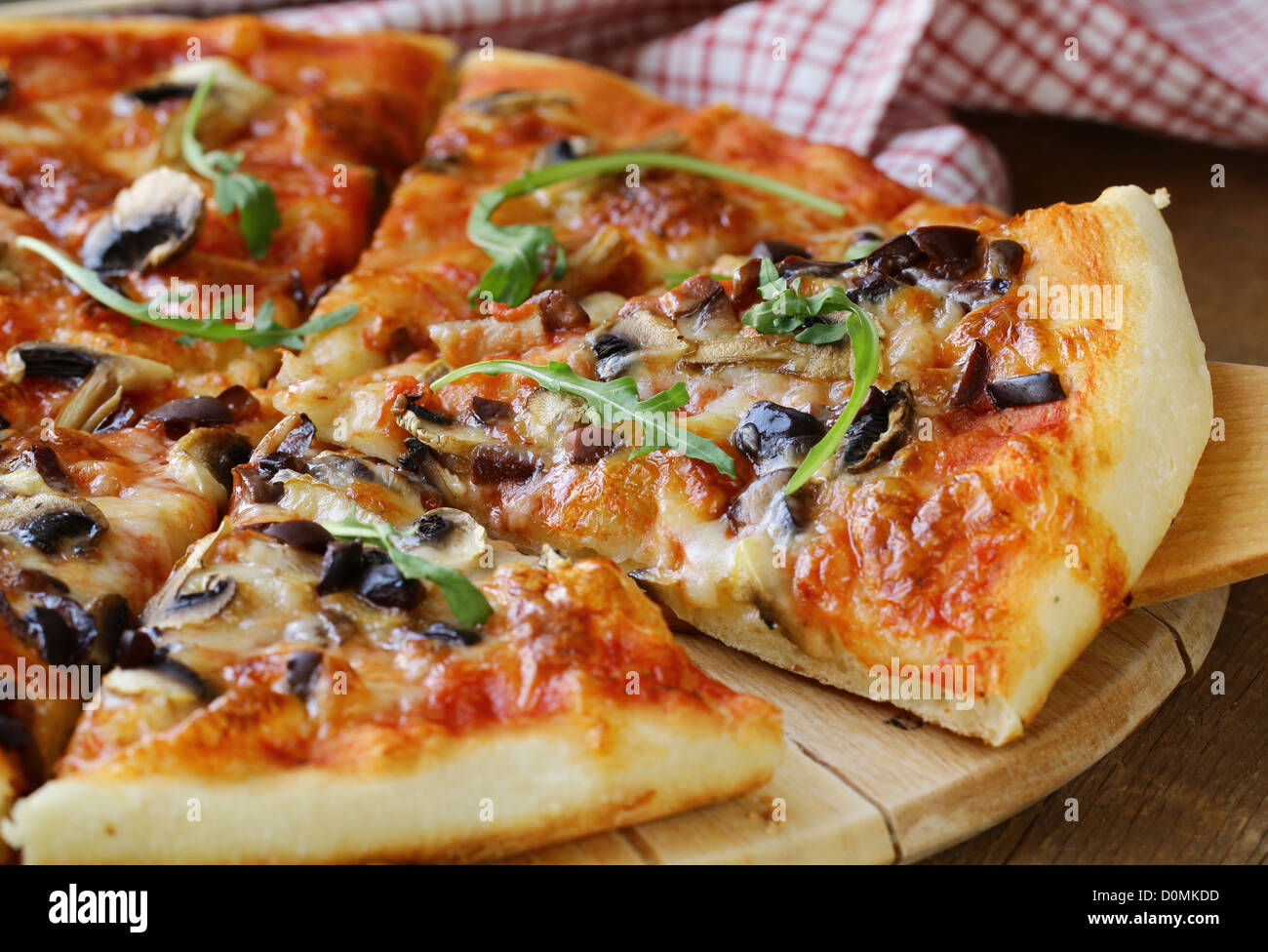 Pizza italienne avec des champignons et des olives sur une planche en bois Banque D'Images