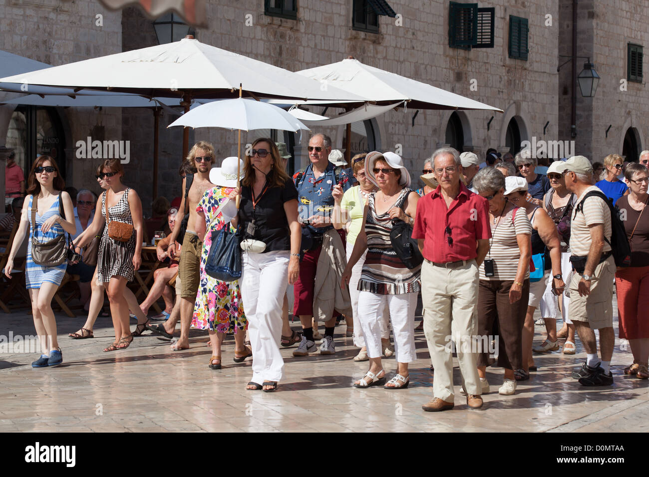 Les touristes sur la rue principale Placa Dubrovnik Croatie menée par guide. Banque D'Images