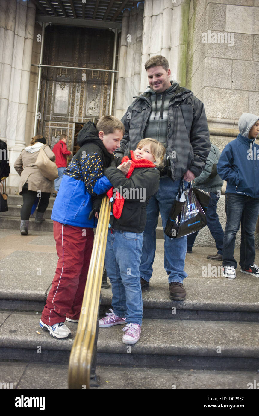 Garçon bousculades avec sa jeune sœur sur les marches de la cathédrale Saint Patrick sur la Cinquième Avenue à New York City, 2012. Banque D'Images