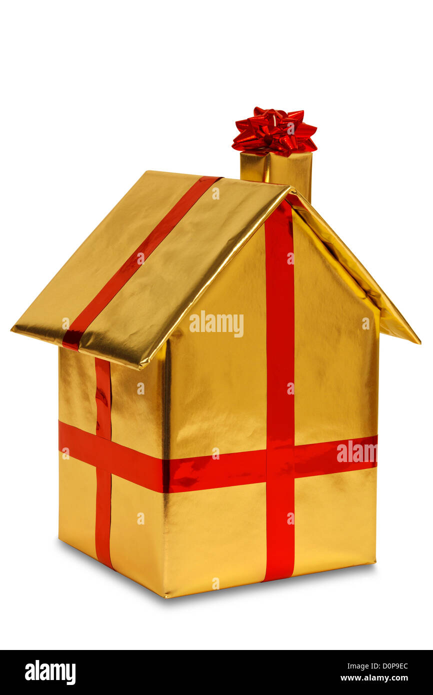 Une nouvelle maison enveloppés dans du papier d'or avec ruban rouge et bow, isolé sur un fond blanc. Banque D'Images
