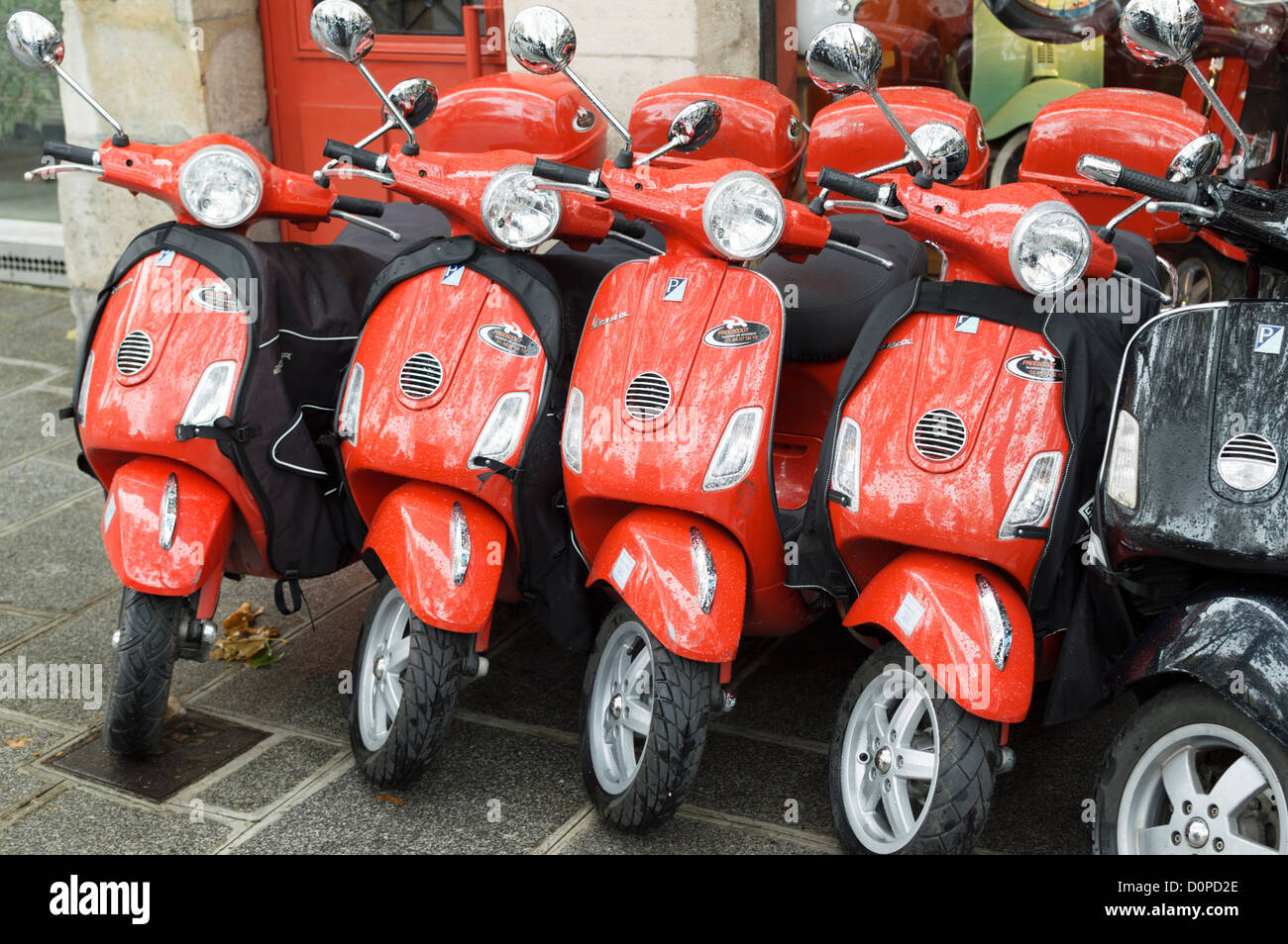 Paris, France : Rouge Piaggio Vespa scooters en location - parqué dans une rangée à l'extérieur d'un magasin de location. Banque D'Images