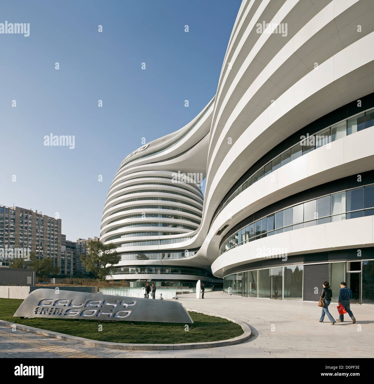 Galaxy Soho, Beijing, Chine. Architecte : Zaha Hadid Architects, 2012. Perspective de la rue et façade avec logo. Banque D'Images