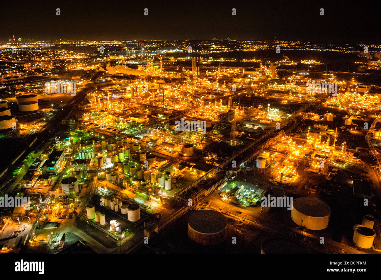 LINDEN/ELIZABETH, New Jersey, États-Unis — une vue aérienne de la raffinerie de Bayway, capturée la nuit depuis un hélicoptère à environ 500 pieds d'altitude, révèle le vaste complexe industriel brillamment illuminé dans l'obscurité. Le réseau complexe de lumières décrit les structures, les réservoirs et les unités de traitement de la raffinerie, créant un paysage industriel saisissant à la frontière de Linden et Elizabeth, NJ Remarque : un bruit ISO élevé est visible en pleine résolution en raison des conditions de faible luminosité difficiles de la photographie aérienne nocturne. Banque D'Images