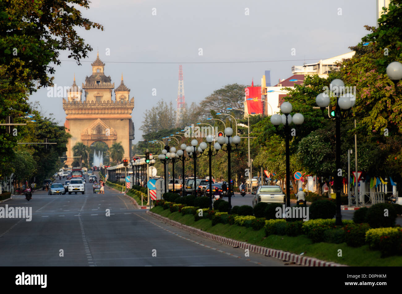 Patuxai Victory Gate Avenue Lane Xang Vientiane Laos // VIENTIANE, Laos - vue sur l'avenue Xang à Vientiane, Laos, en face du Palais présidentiel. À gauche, au loin se trouve Patuxai (porte de la victoire ou porte du Triomphe), un mémorial de guerre. Elle est également connue familièrement comme la « piste verticale » parce qu'elle est fabriquée à partir de béton fourni par American Aid pour construire un aéroport qui n'a jamais été terminé. Il est aussi parfois translittéré comme Patuxai, Patuxay, Patousai et Patusai Banque D'Images