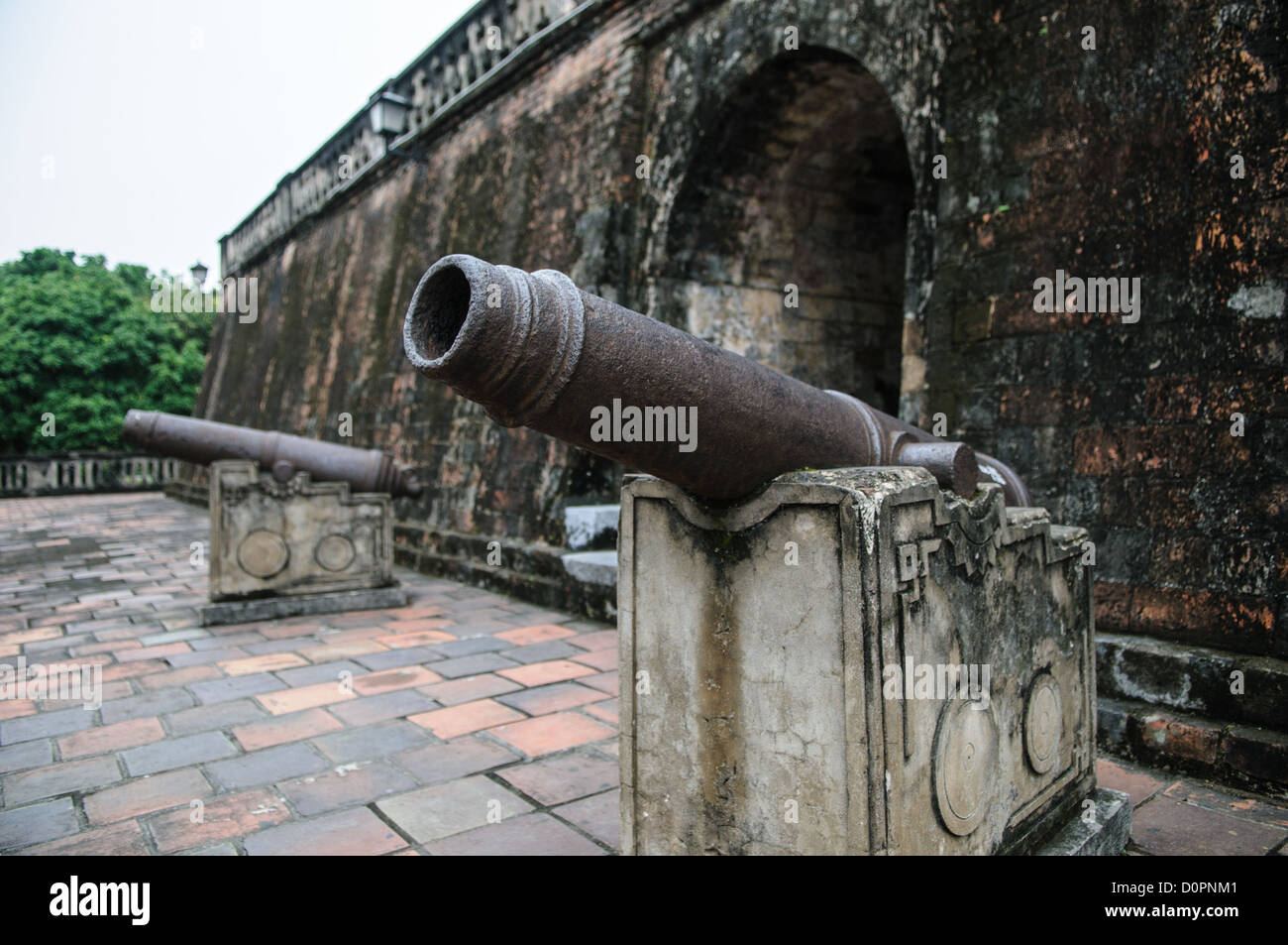 HANOI, Vietnam — des canons historiques sont exposés à la base de la tour du drapeau de Hanoi au Musée d'histoire militaire du Vietnam. Ces pièces d'artillerie font partie de la vaste collection de matériel militaire historique du musée. L'emplacement des canons autour de la tour du XIXe siècle crée une exposition saisissante du patrimoine militaire du Vietnam. Banque D'Images