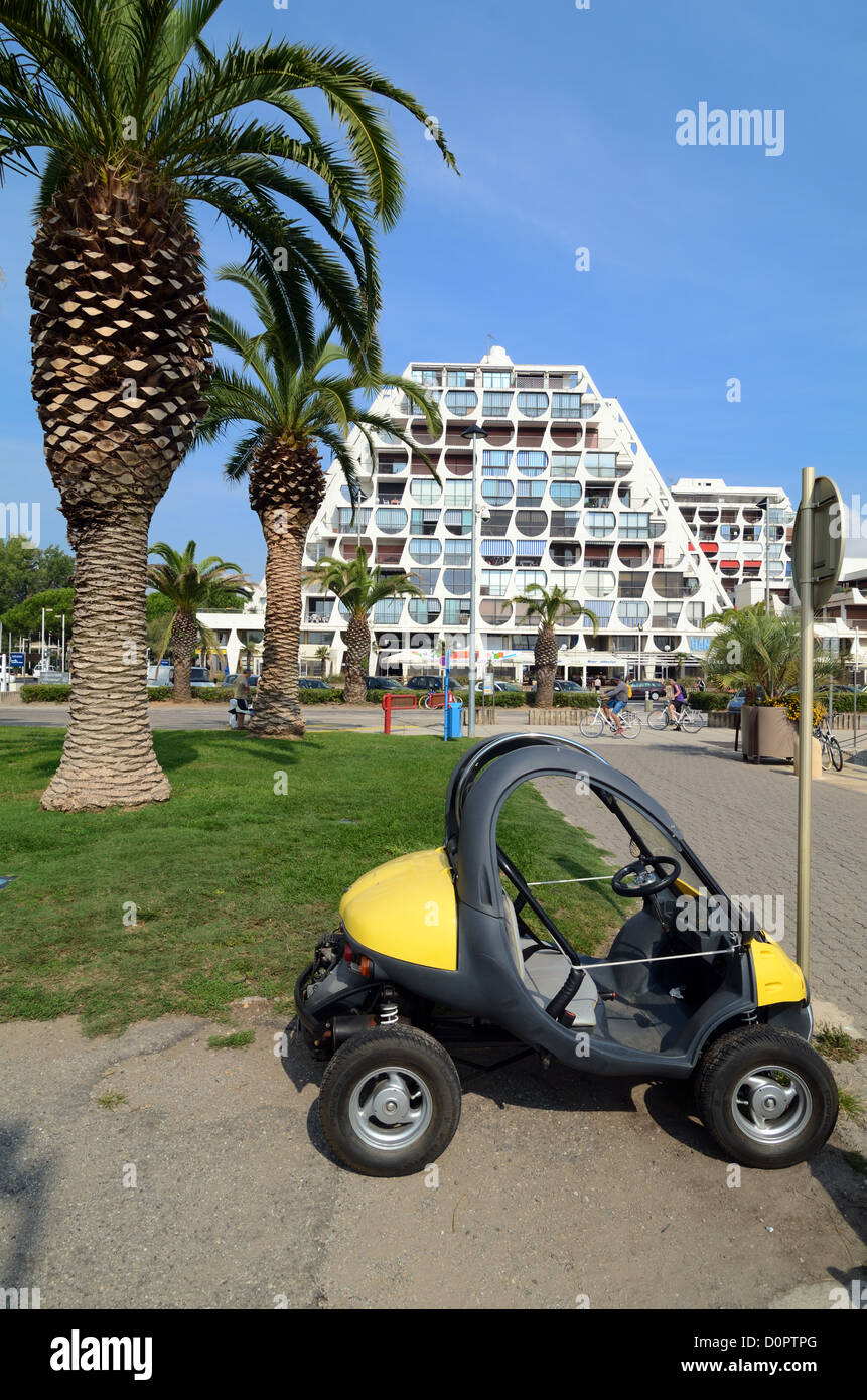 Petite voiture électrique, Microcar ou Buggy garée en face du Delta Building (1971) par Jean Balladur dans la Nouvelle ville de la Grande-Motte Hérault France Banque D'Images