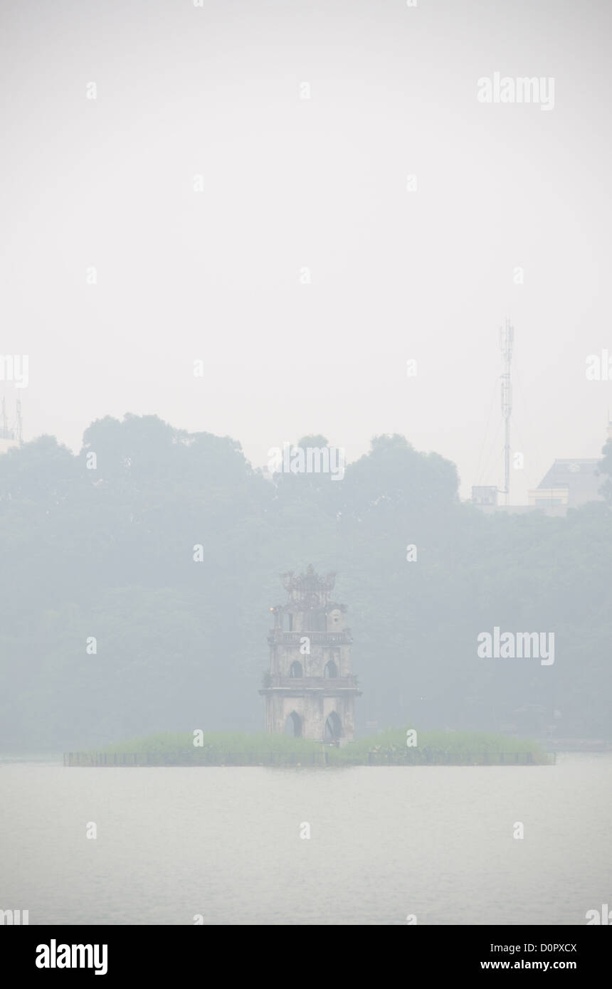Tour des tortues Lac Hoan Kiem dans le brouillard Hanoi Vietnam // HANOI, Vietnam — Tour des tortues (Thap Rua), sur une petite île au milieu du lac Hoan Kiem au cœur de Hanoi, est partiellement obscurcie par un épais brouillard matinal. Copyspace en haut du cadre. Banque D'Images