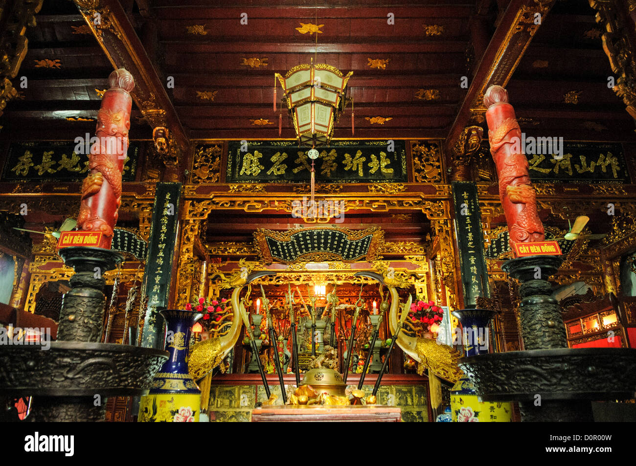 HANOI, Vietnam — Un autel de dévotion se dresse dans une chapelle latérale de la pagode Tran Quoc sur l'îlot Golden Fish du lac de l'Ouest. L'autel, avec des éléments de design bouddhiste vietnamien traditionnel, sert d'espace de culte parmi plusieurs dans le complexe du temple. Ce sanctuaire illustre les traditions artistiques religieuses maintenues depuis le déménagement du temple en 1615. Banque D'Images