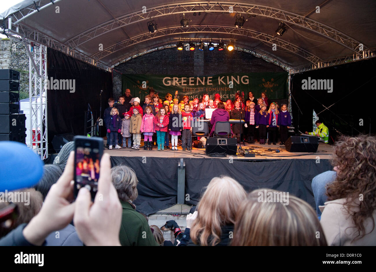 Les enfants de l'école primaire de chanter sur scène en public, marché de Noël de Bury St Edmunds, Suffolk Angleterre UK Banque D'Images