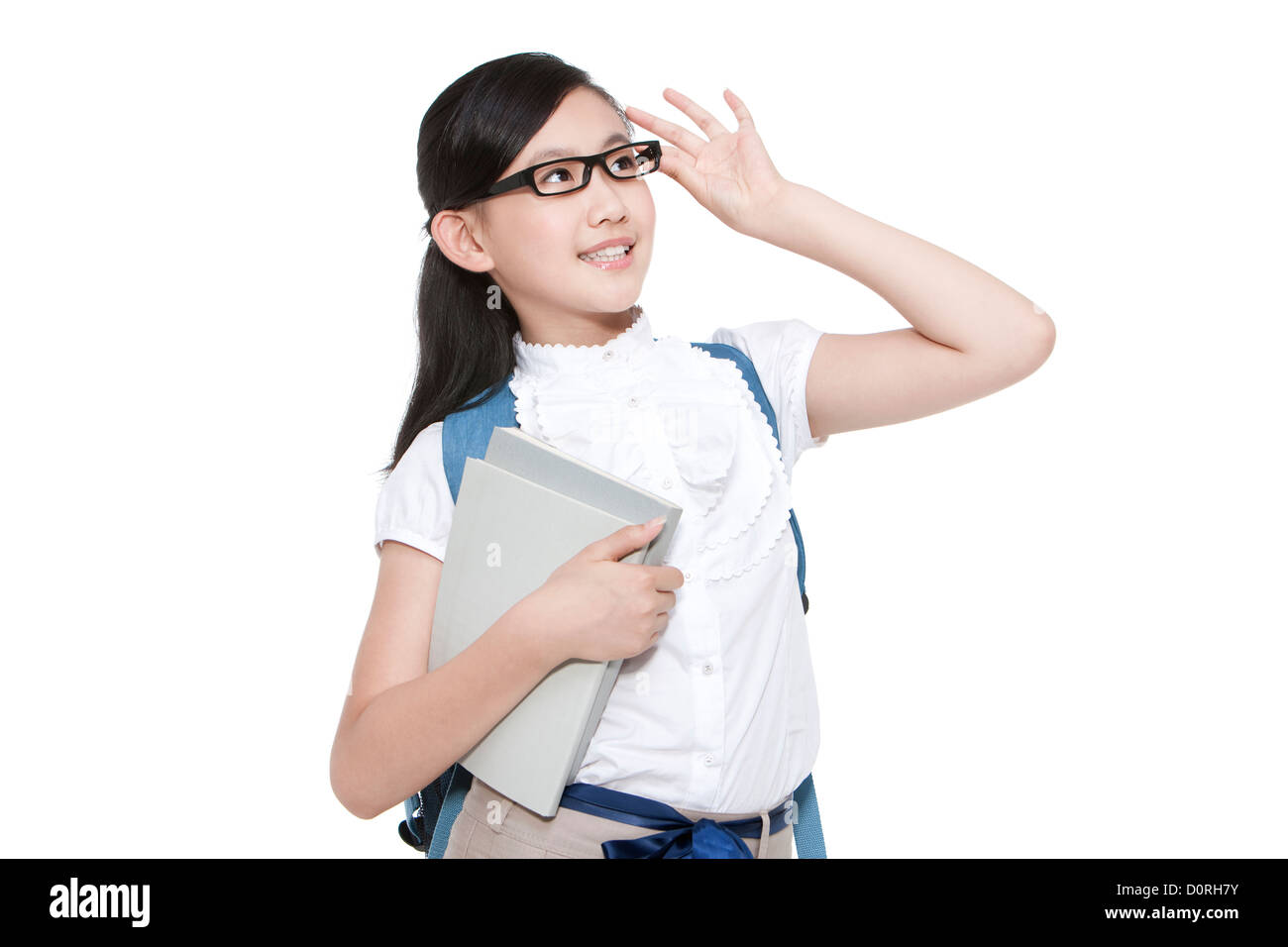 Jolie lycéenne de régler ses lunettes et à la recherche à vue avec books Banque D'Images