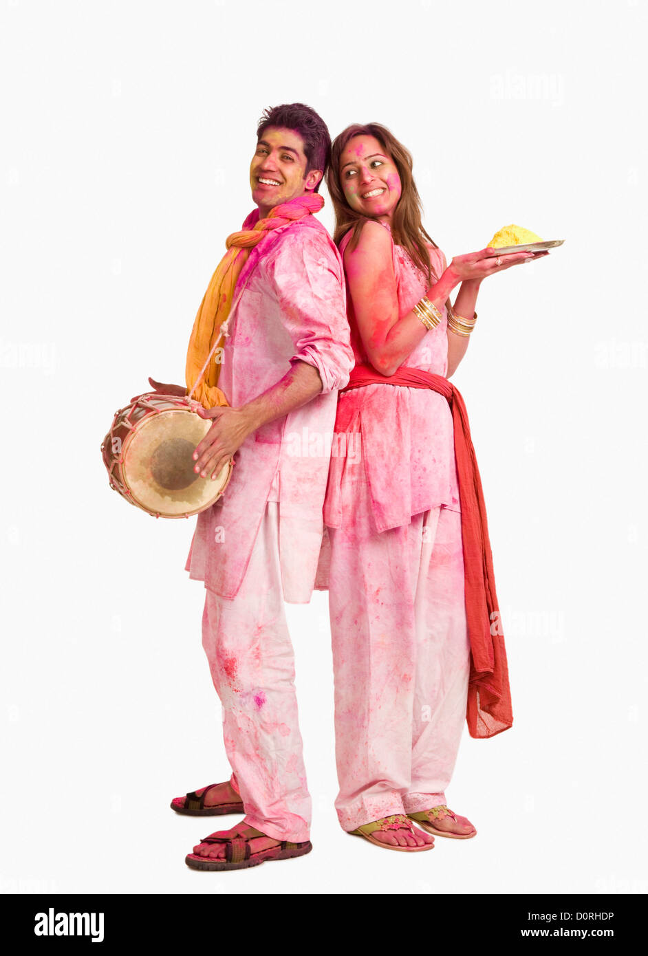 Couples célébrant Holi avec des couleurs et un tambour Banque D'Images