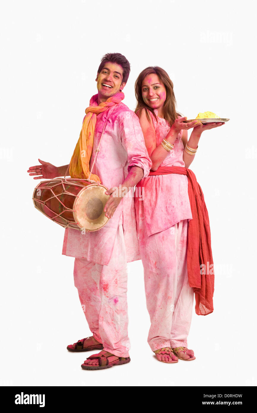 Couples célébrant Holi avec des couleurs et un tambour Banque D'Images