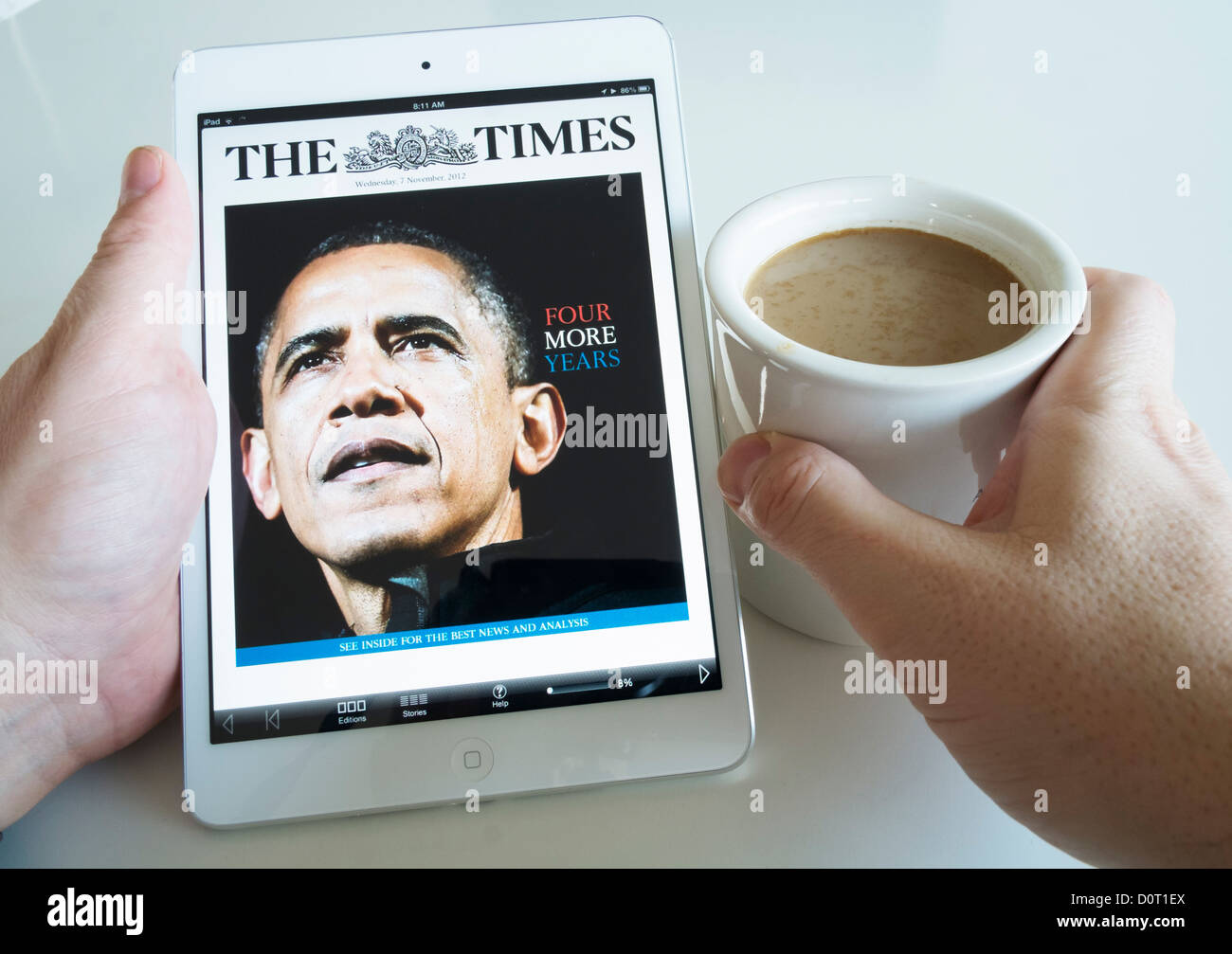 À l'aide d'un iPad mini ordinateur pour lire le journal Times Digital edition Banque D'Images