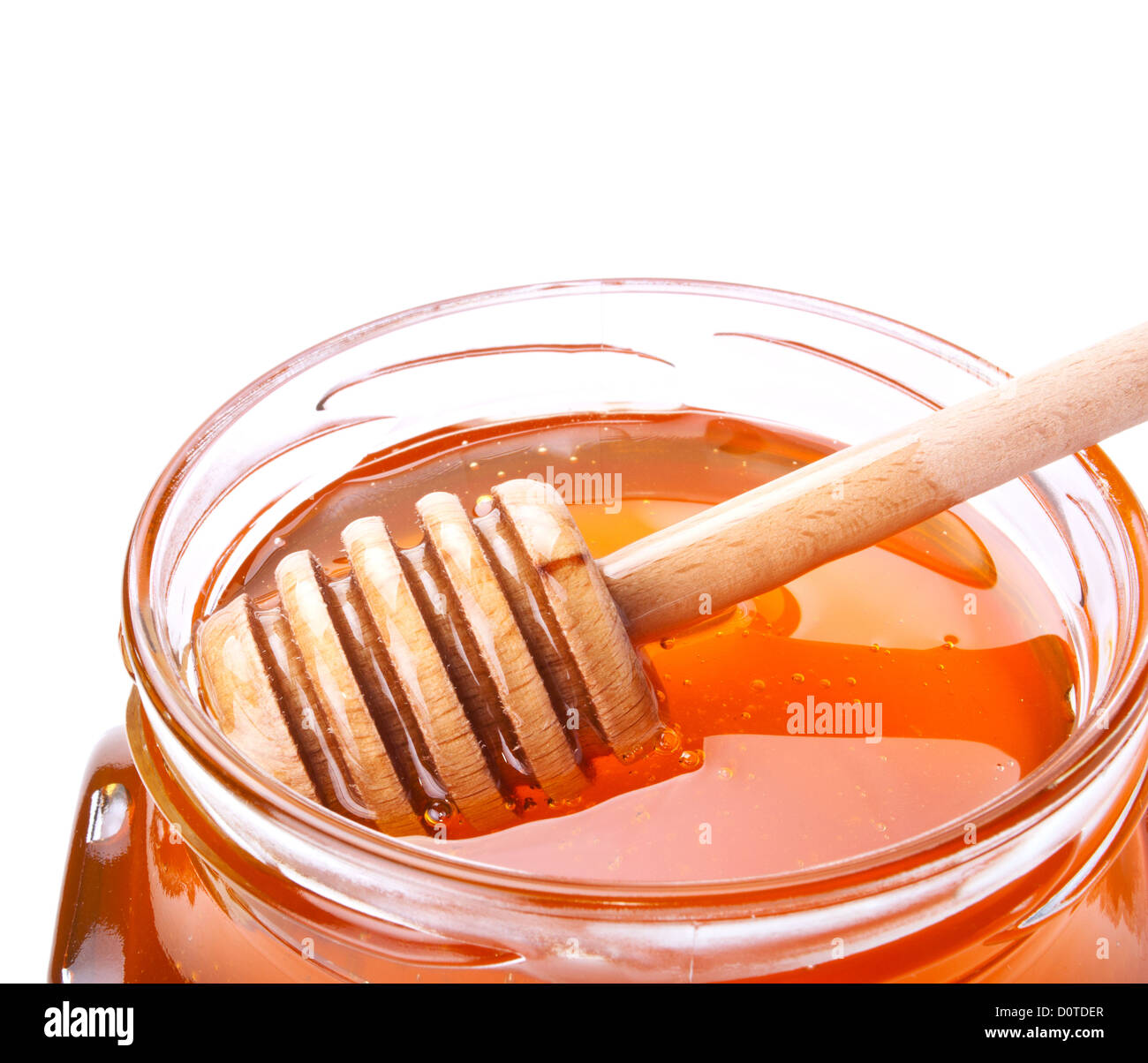 Pot de miel en verre avec un drizzler sur fond blanc Banque D'Images