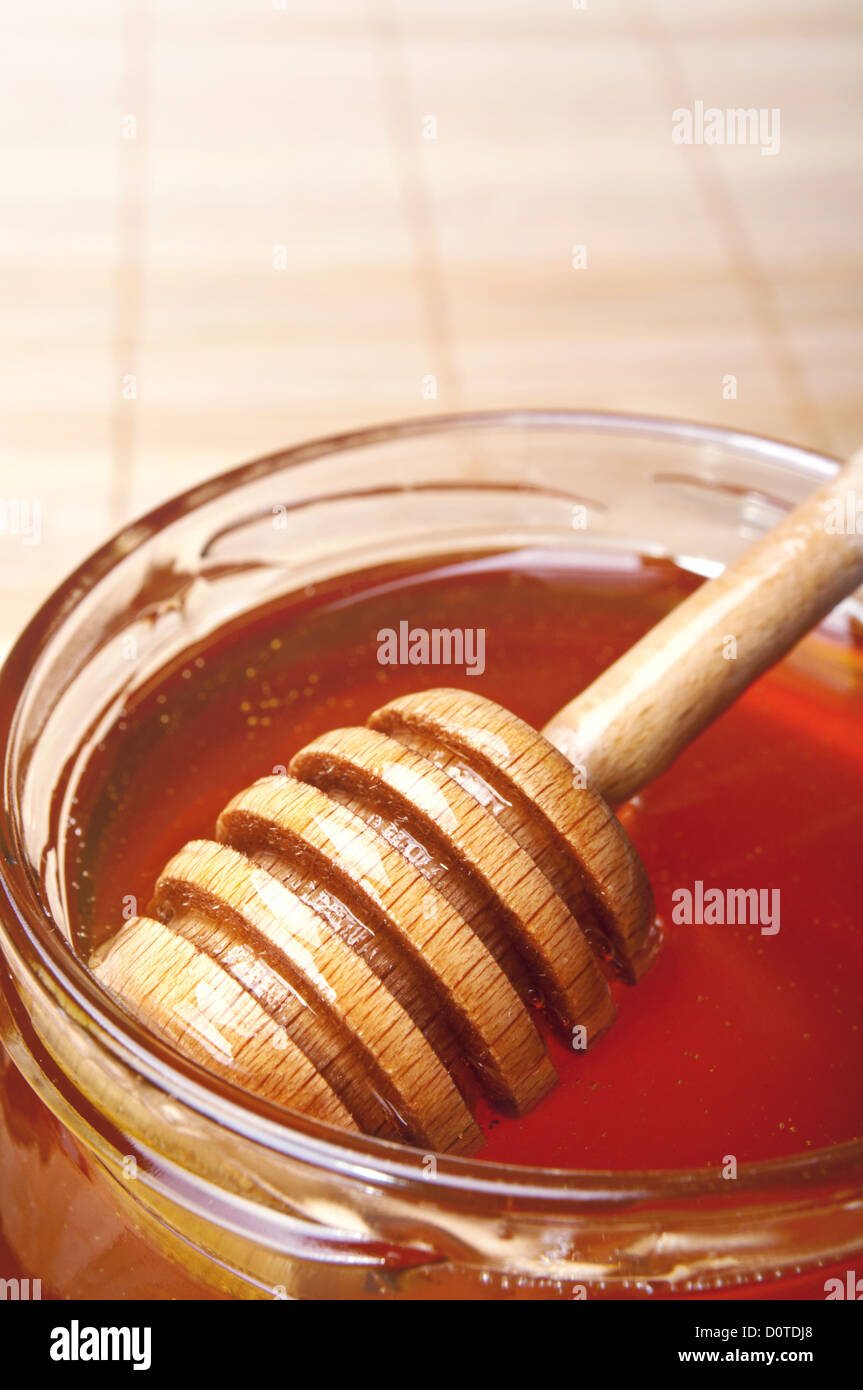 Pot de miel en verre avec un drizzler sur bambou Banque D'Images