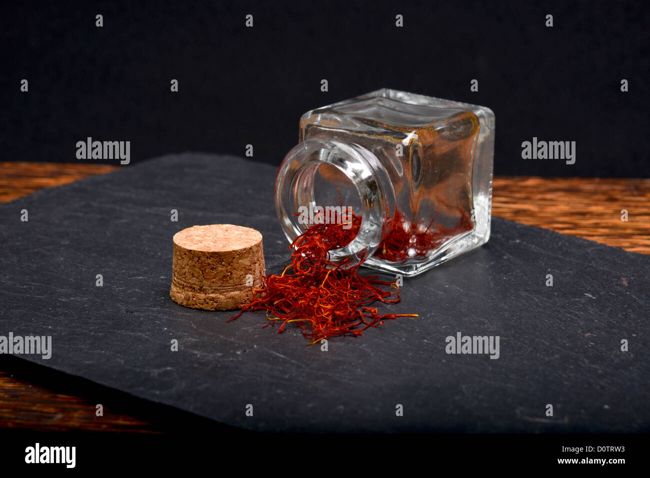 Safran espagnol de renverser un pot de verre sur une ardoise naturelle. Banque D'Images