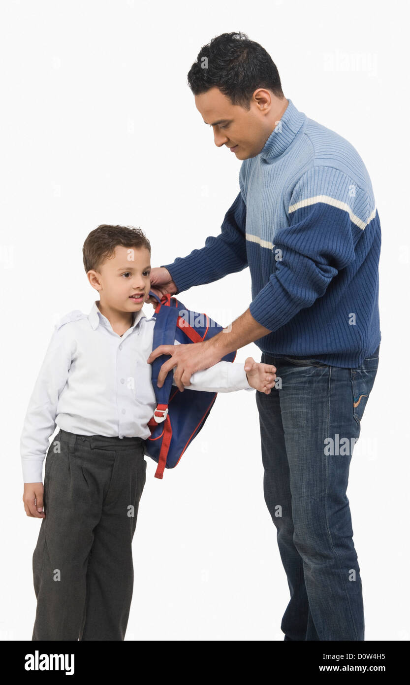 L'homme s'habille son fils pour l'école Banque D'Images