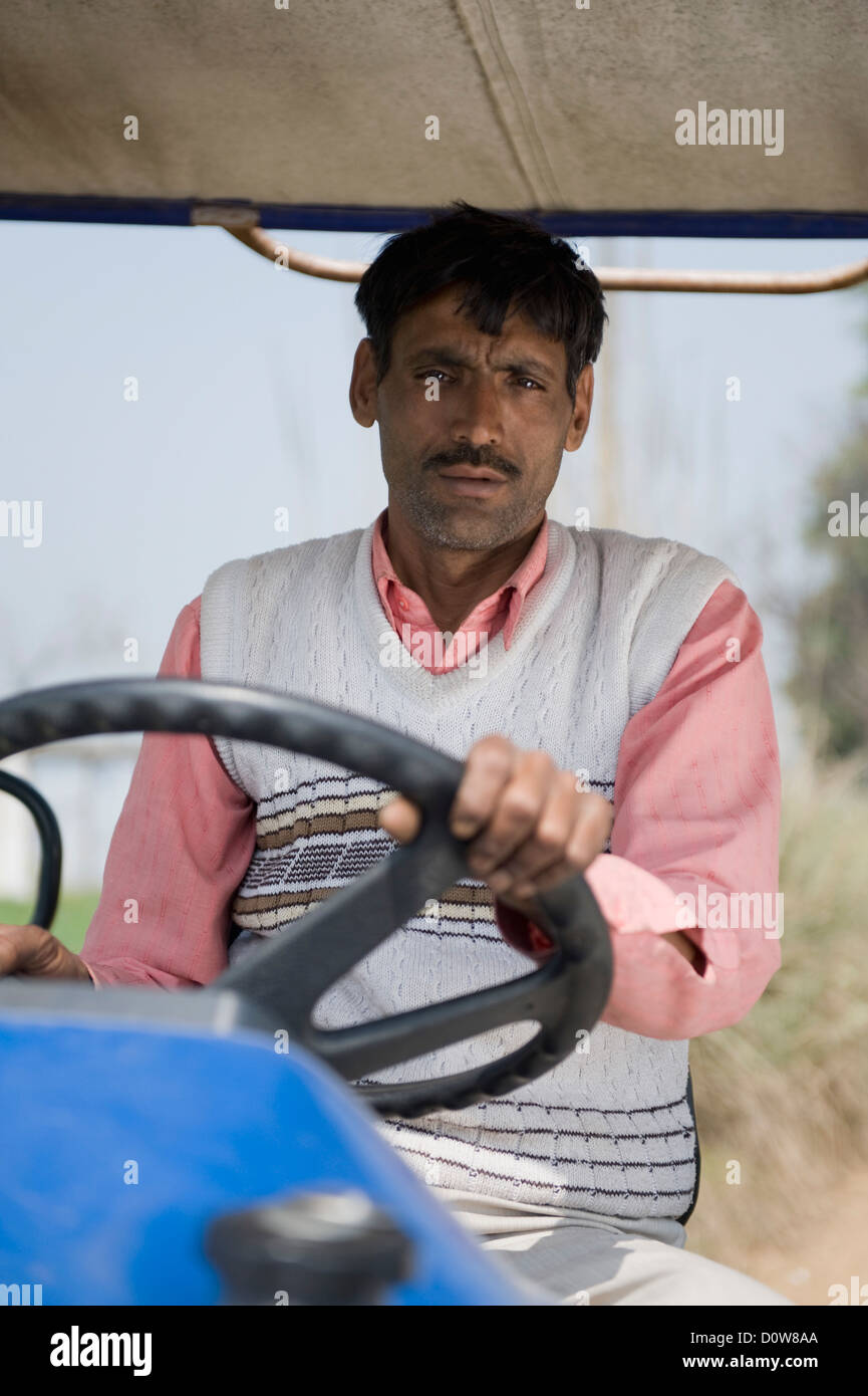 Portrait d'un agriculteur au volant d'un tracteur, Farrukh Nagar, Gurgaon, Haryana, Inde Banque D'Images