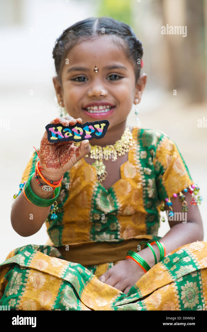 Smiling Indian girl holding a Happy broderie multicolore patch. L'Andhra Pradesh, Inde Banque D'Images