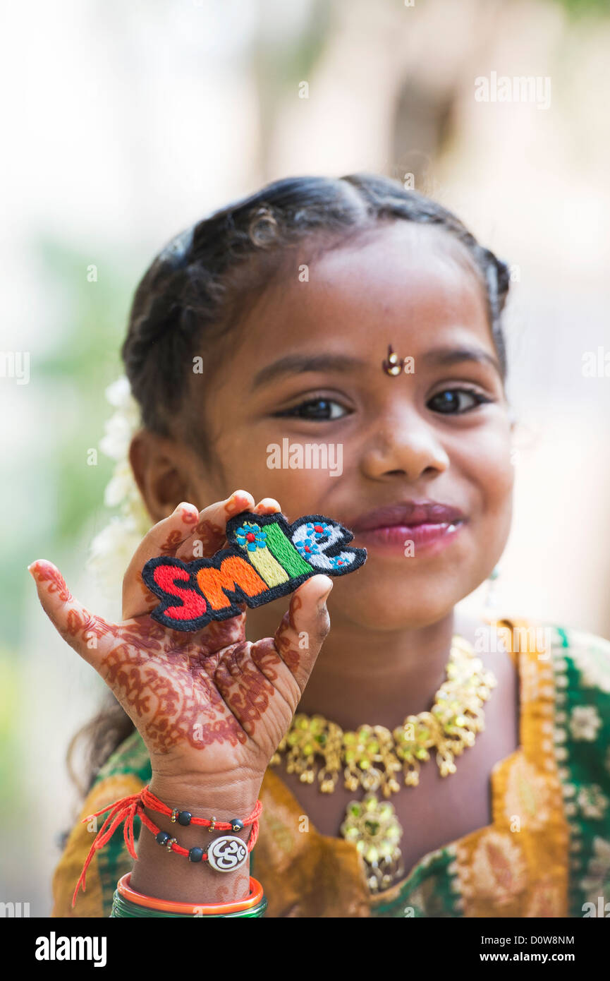 Smiling Indian girl holding a patch broderie multicolore sourire. L'Andhra Pradesh, Inde Banque D'Images