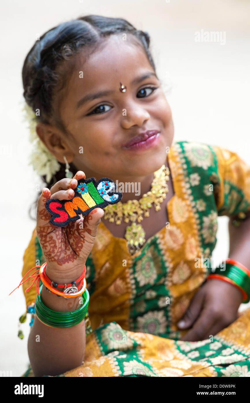Smiling Indian girl holding a patch broderie multicolore sourire. L'Andhra Pradesh, Inde Banque D'Images