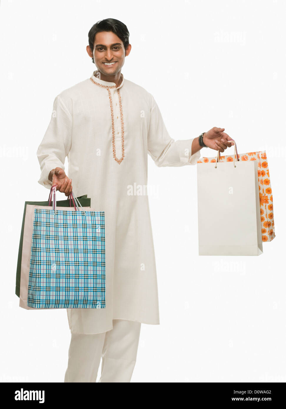 Bengali man carrying shopping bags and smiling Banque D'Images