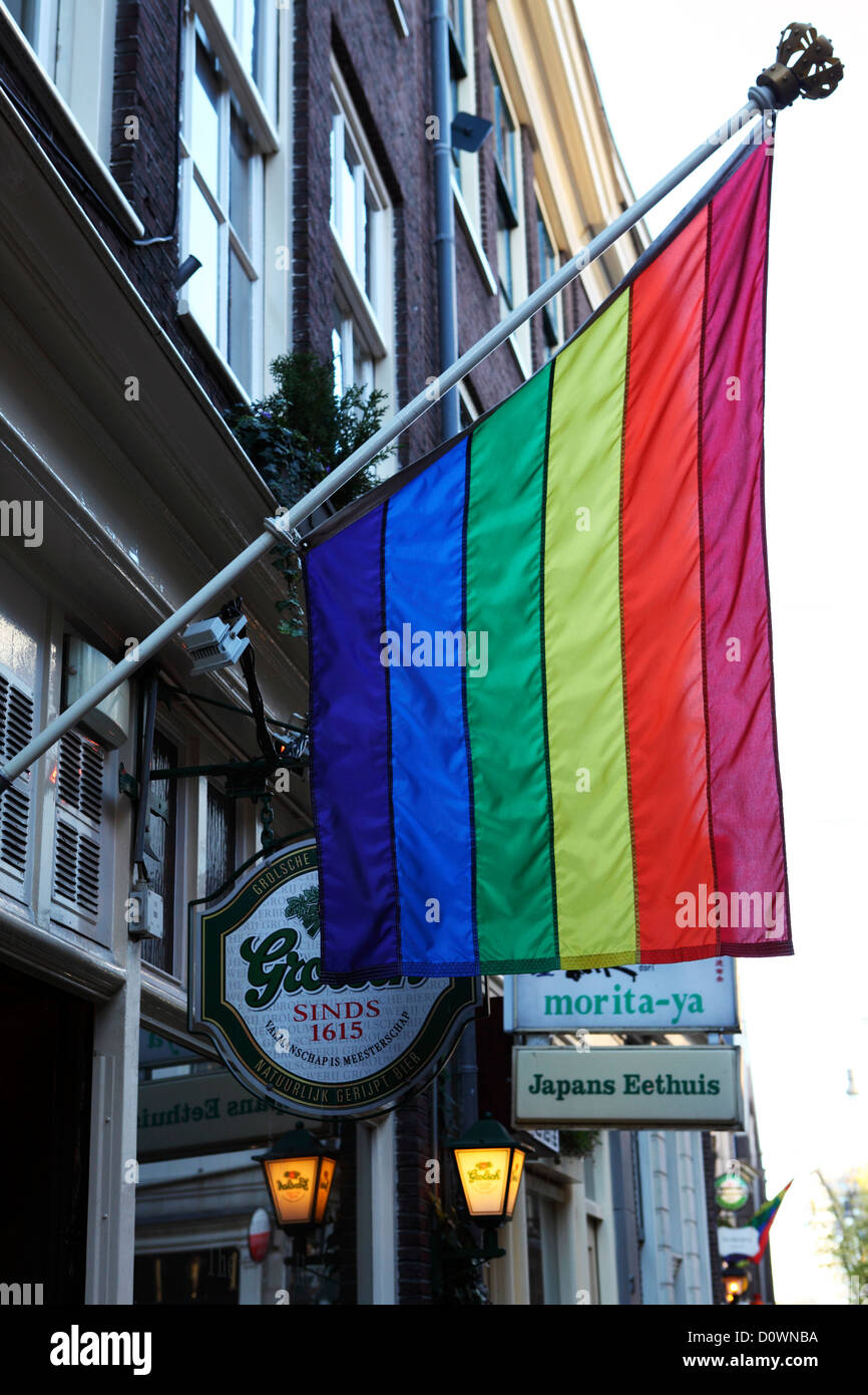 Une couleur arc-en-ciel drapeau flotte à l'extérieur d'un bar au centre d'Amsterdam, aux Pays-Bas. Banque D'Images