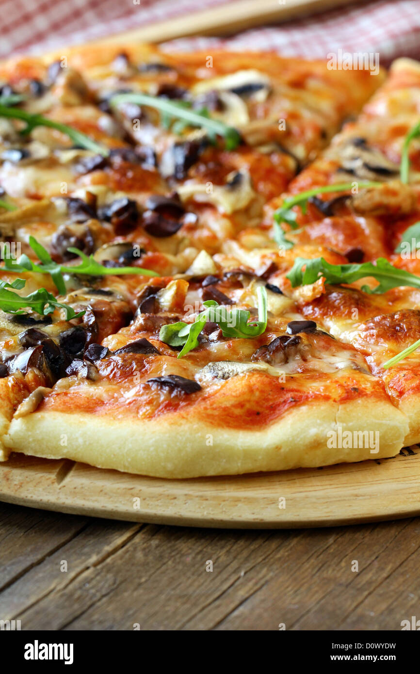 Pizza italienne avec des champignons et des olives sur une planche en bois Banque D'Images