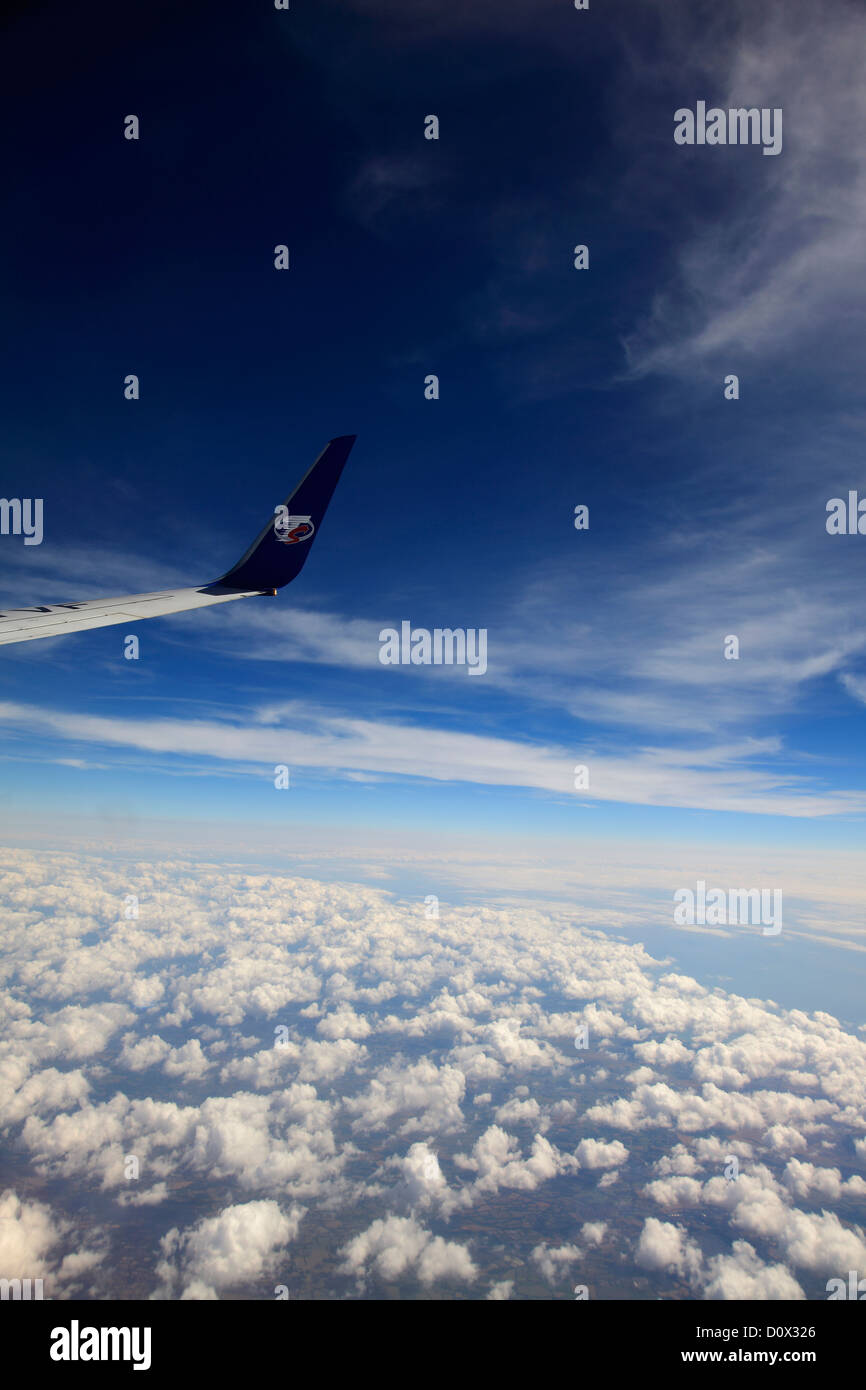 Vue depuis la fenêtre de l'avion des compagnies aériennes et TS logo aile, Golfe de Gascogne, côtes françaises avec Altocumulus Stratiformis nuages. Banque D'Images