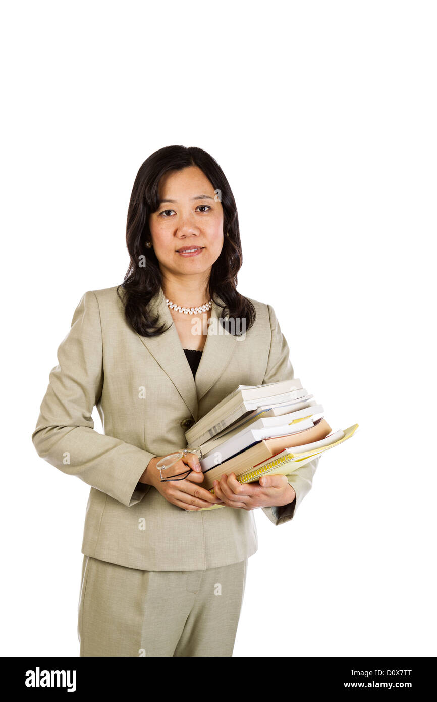 Femme Asiatique mature teacher holding pile de livres et des verres sur fond blanc Banque D'Images