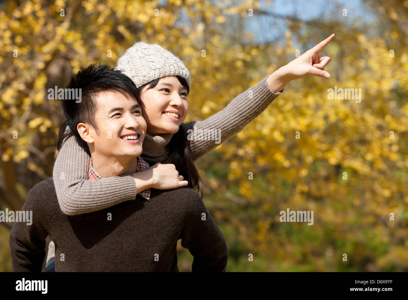 Happy young couple in love pointant vers l'avant à l'extérieur à l'automne Banque D'Images